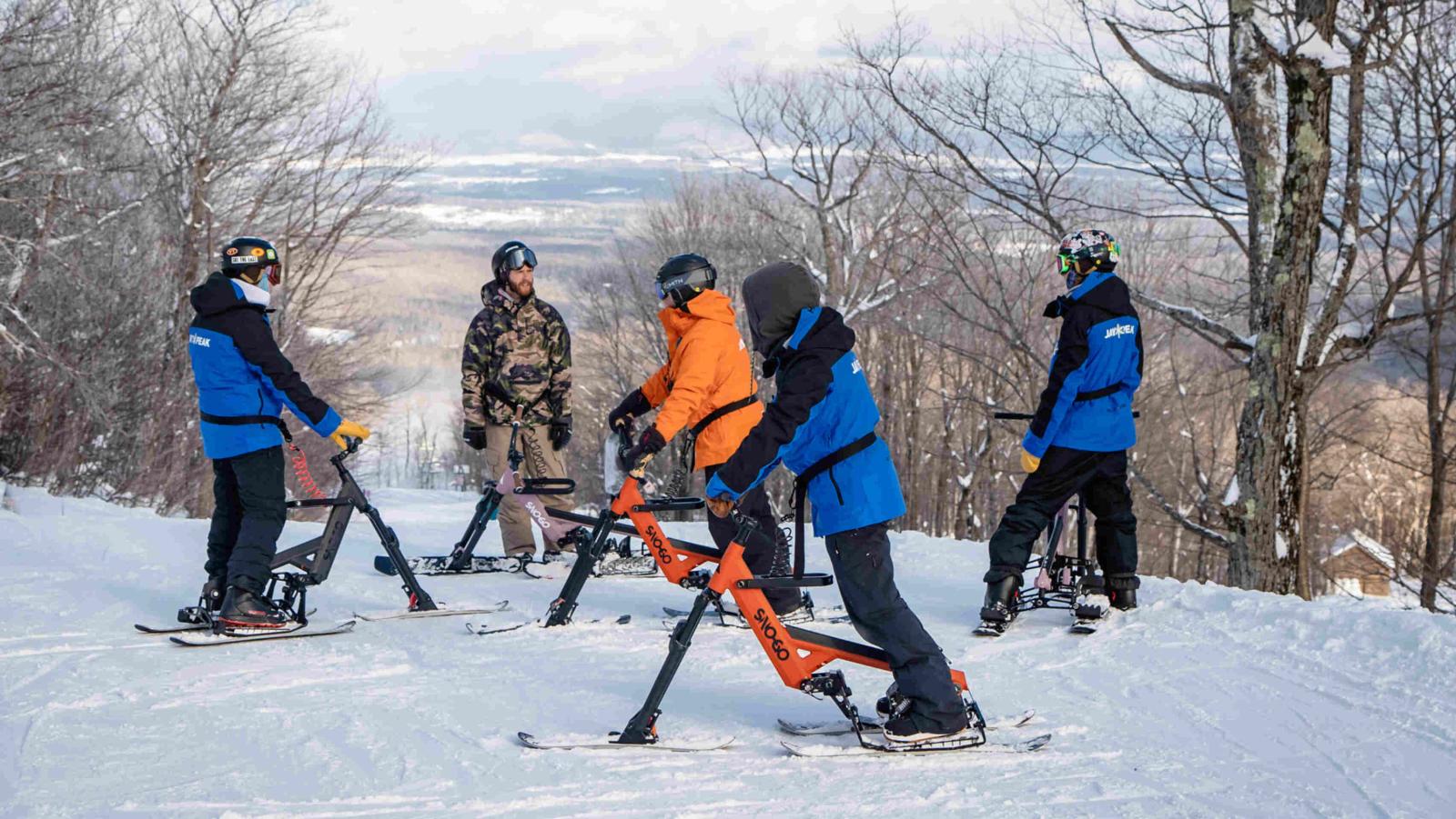 Group hanging out on the mountainside with SNO GO bikes